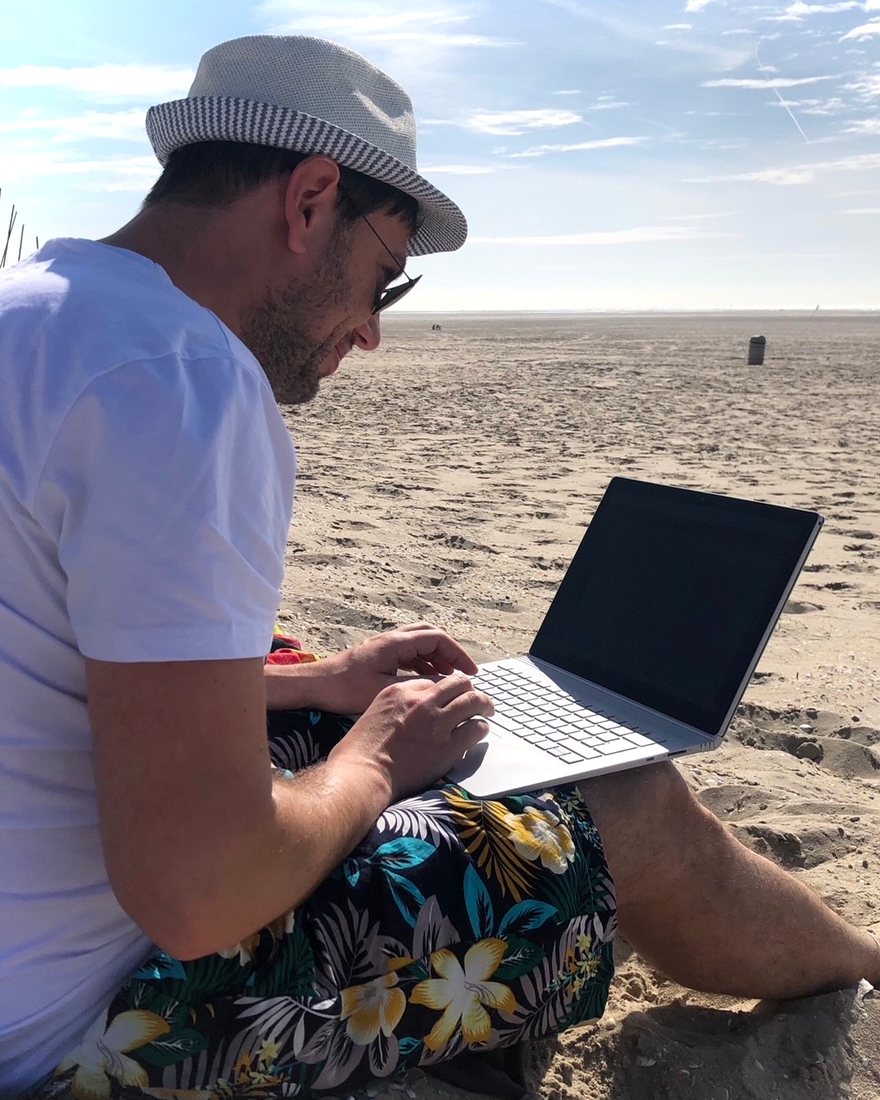 Carsten Tschirner arbeitet mit dem Laptop am Strand